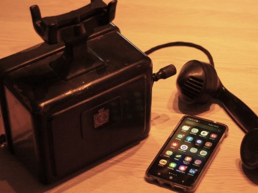 a black phone next to a black box with a cord