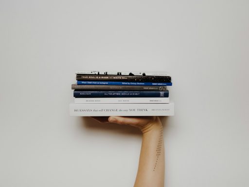 person holding pile of books