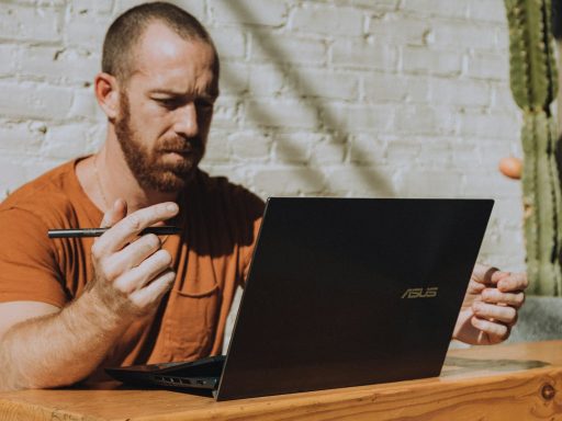 a man sitting at a table using a laptop computer