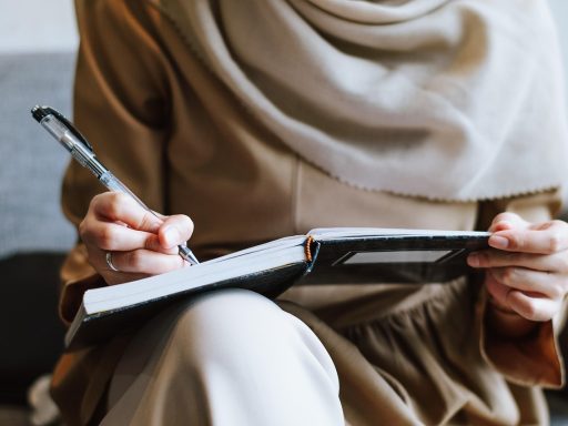 Vrouw die peinzend schrijft in een notitieboek in een café