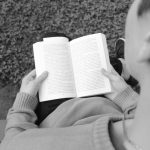 Persoon leest een boek met een kop koffie, nadenken over carrièreswitch