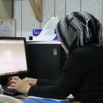 Persoon die vermoeid achter een bureau zit op kantoor en motivatie kwijt lijkt