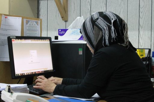 Persoon die vermoeid achter een bureau zit op kantoor en motivatie kwijt lijkt