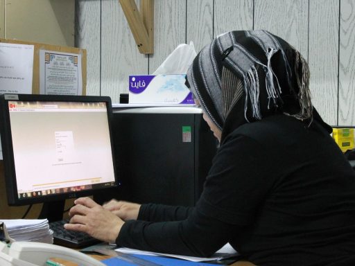 Persoon die vermoeid achter een bureau zit op kantoor en motivatie kwijt lijkt