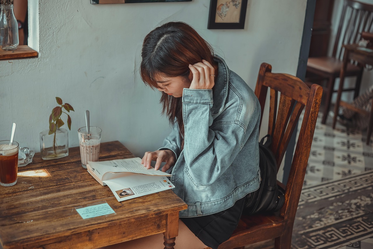 Jonge vrouw schrijft in notitieboekje aan een tafeltje in een café