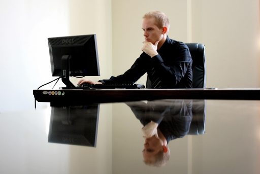 Vrouw in leiderschapspositie die nadenkend achter haar bureau zit
