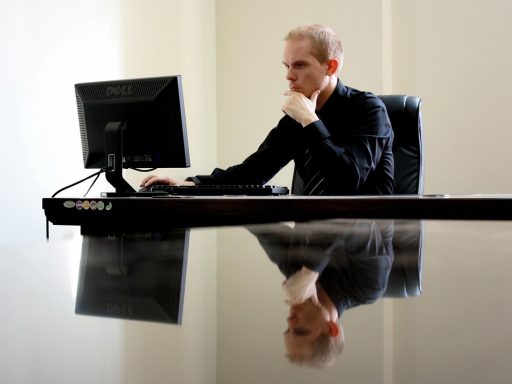 Vrouw in leiderschapspositie die nadenkend achter haar bureau zit