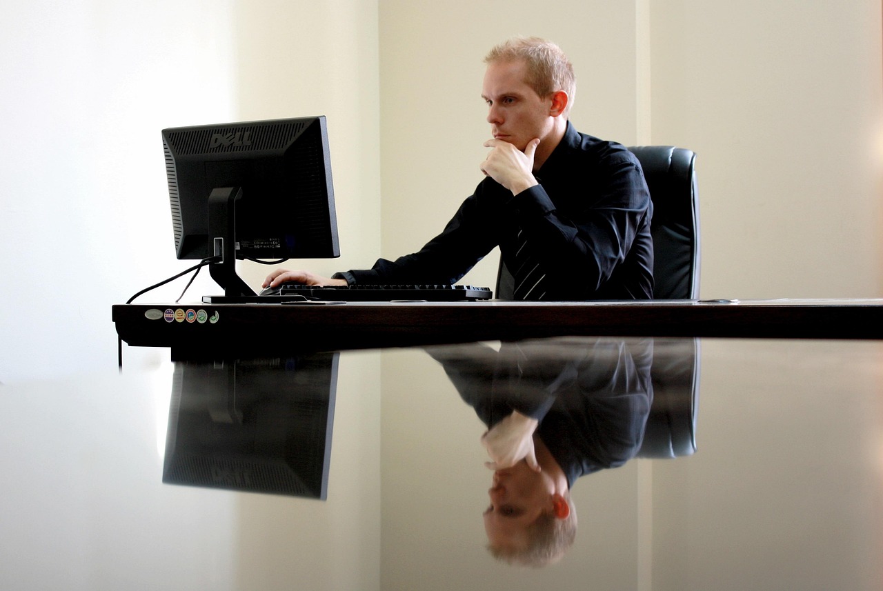 Vrouw in leiderschapspositie die nadenkend achter haar bureau zit