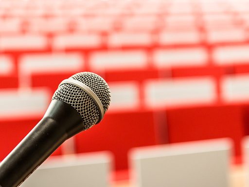 Volle zaal met publiek bij een nachtelijke filosofielezing