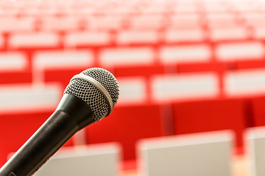 Volle zaal met publiek bij een nachtelijke filosofielezing