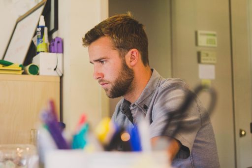 Freelancer die alleen werkt aan een bureau thuis, met een laptop voor zich