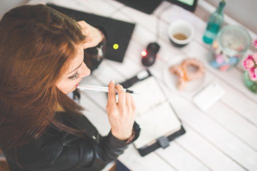 Vrouw die nadenkend achter haar bureau zit op kantoor