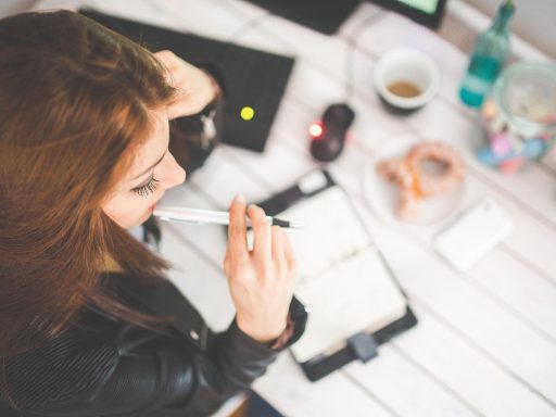 Vrouw die nadenkend achter haar bureau zit op kantoor