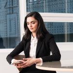 Vrouw in goed zittende blazer aan haar bureau op kantoor