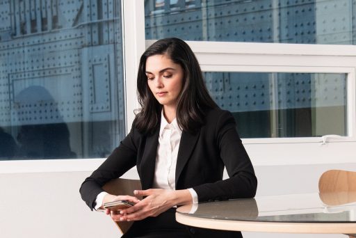 Vrouw in goed zittende blazer aan haar bureau op kantoor