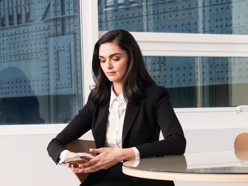 Vrouw in goed zittende blazer aan haar bureau op kantoor