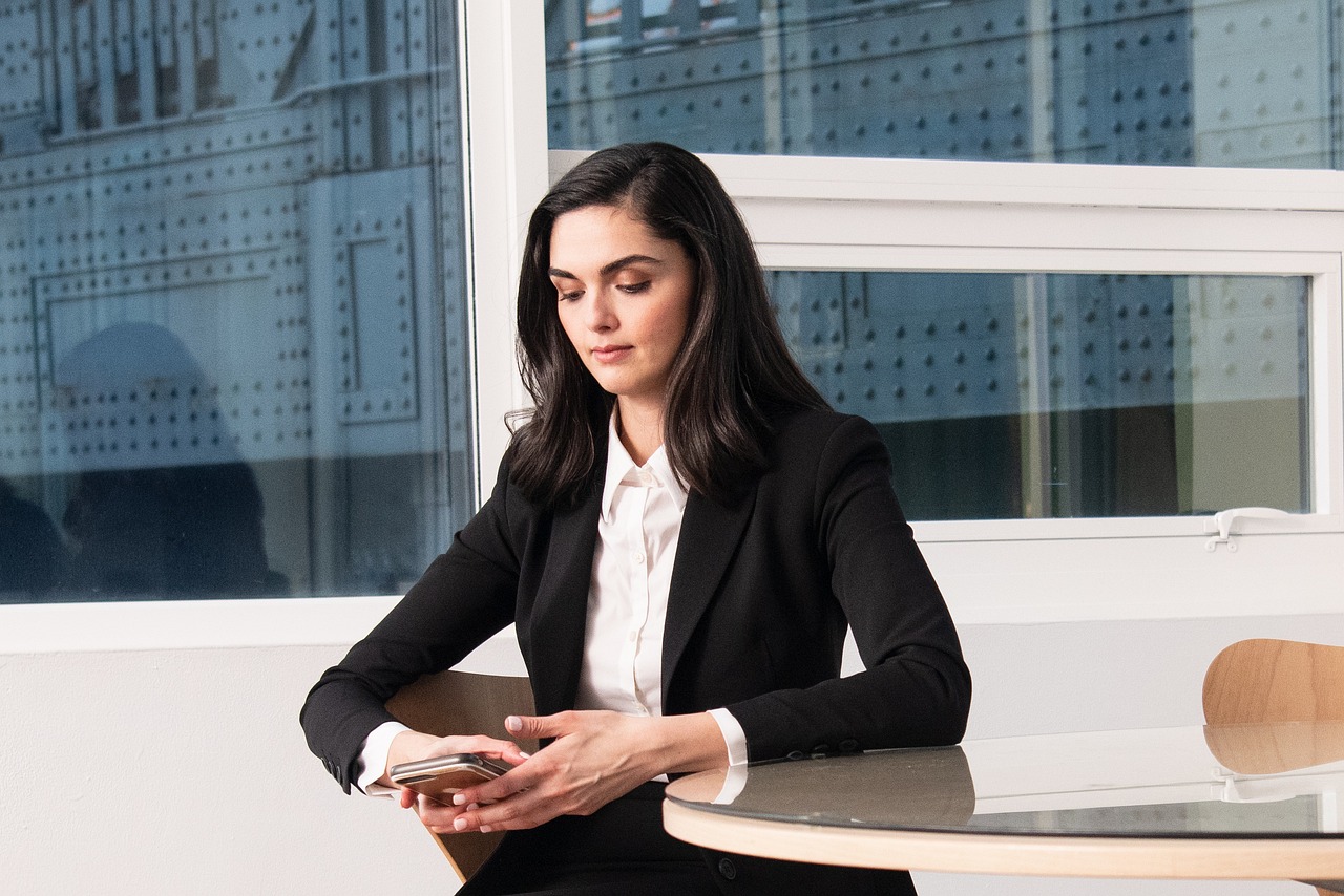 Vrouw in goed zittende blazer aan haar bureau op kantoor