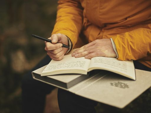 Persoon schrijft persoonlijke doelen in een notitieboek aan een bureau