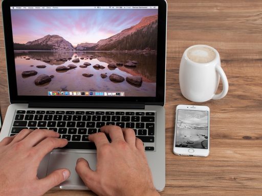 Freelancer werkt geconcentreerd op laptop in een koffiebar tijdens een acquisitiesessie