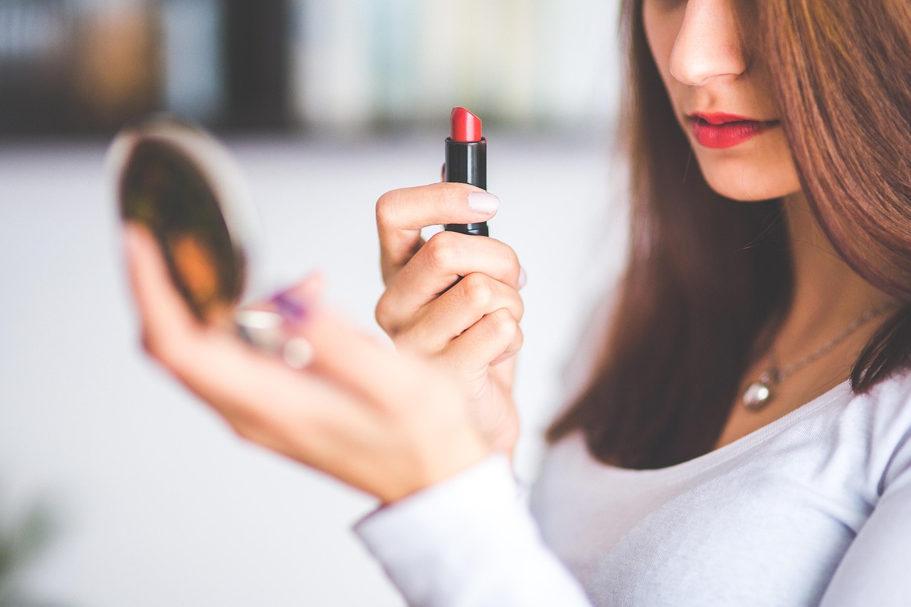 Vrouw met grijs haar die make-up aanbrengt voor een spiegel