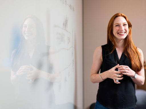 Een vrouw zit zelfverzekerd aan een vergadertafel tijdens een zakelijk gesprek